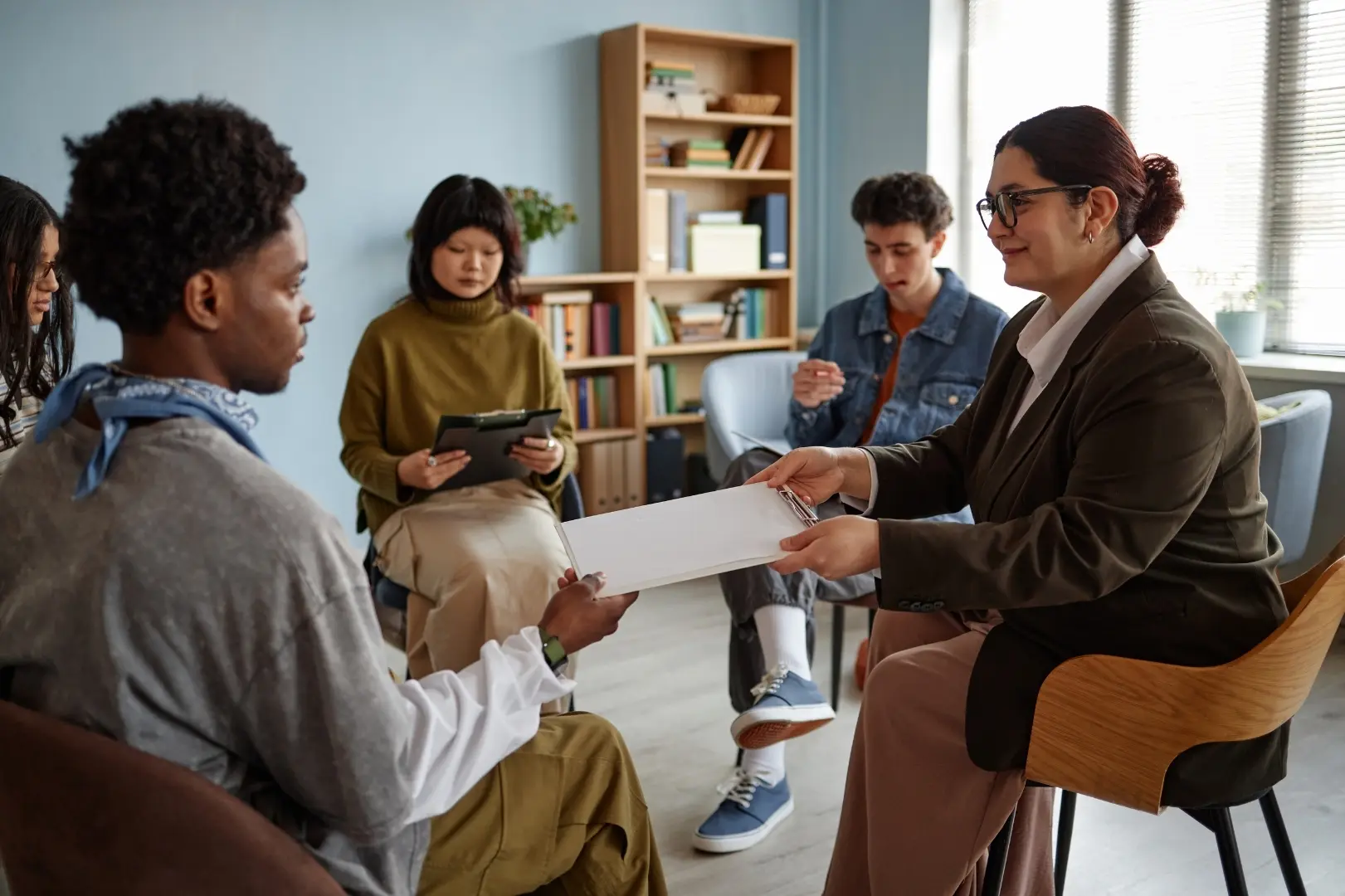A facilitator leading a supportive group discussion with young people
